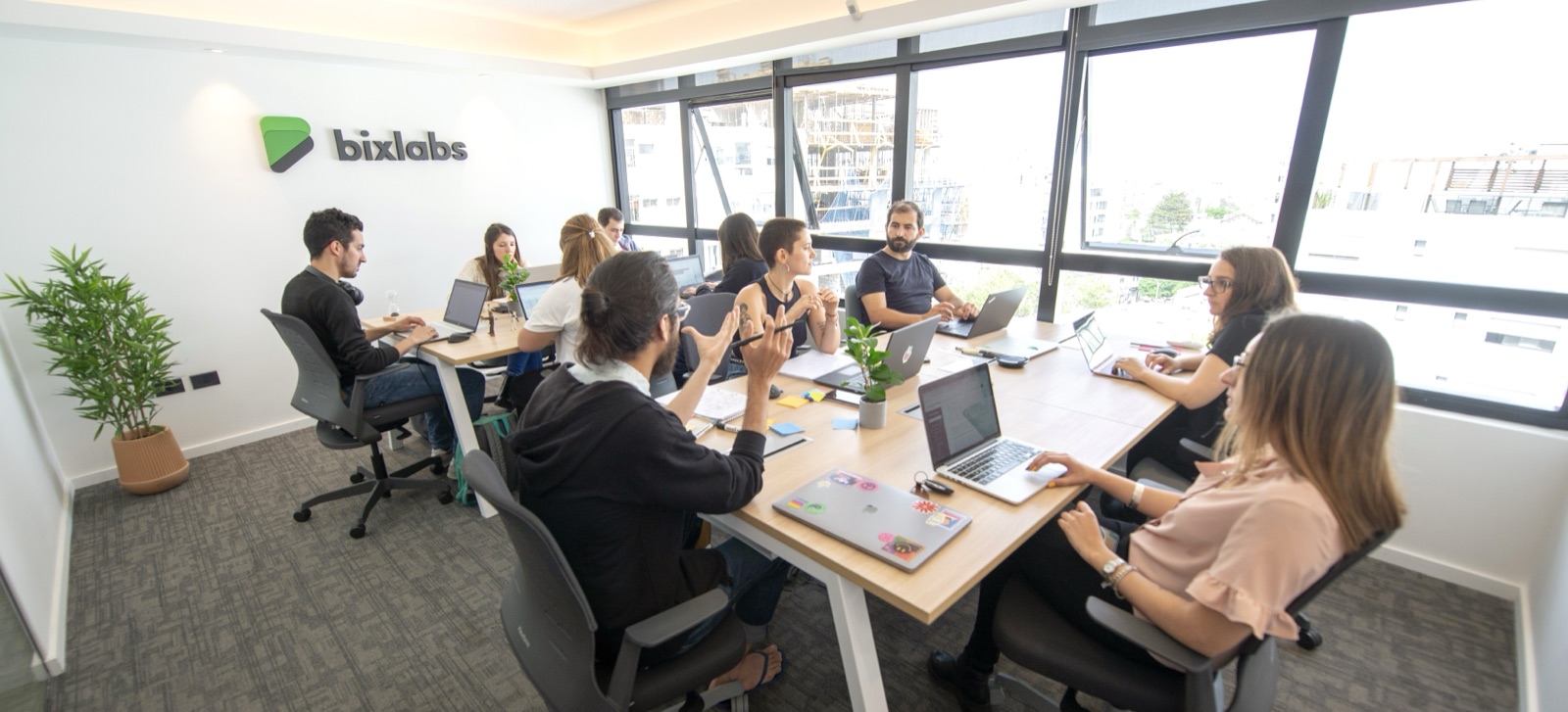 The Bixlabs team working in the office, with the company logo on the wall
